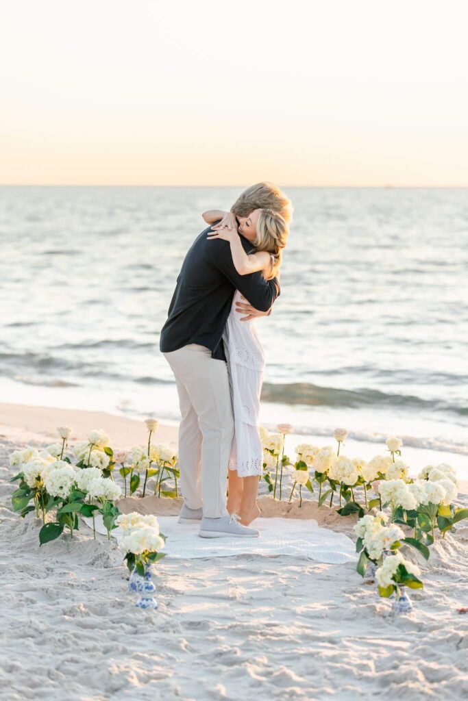 couple embracing after proposal by naples photographer