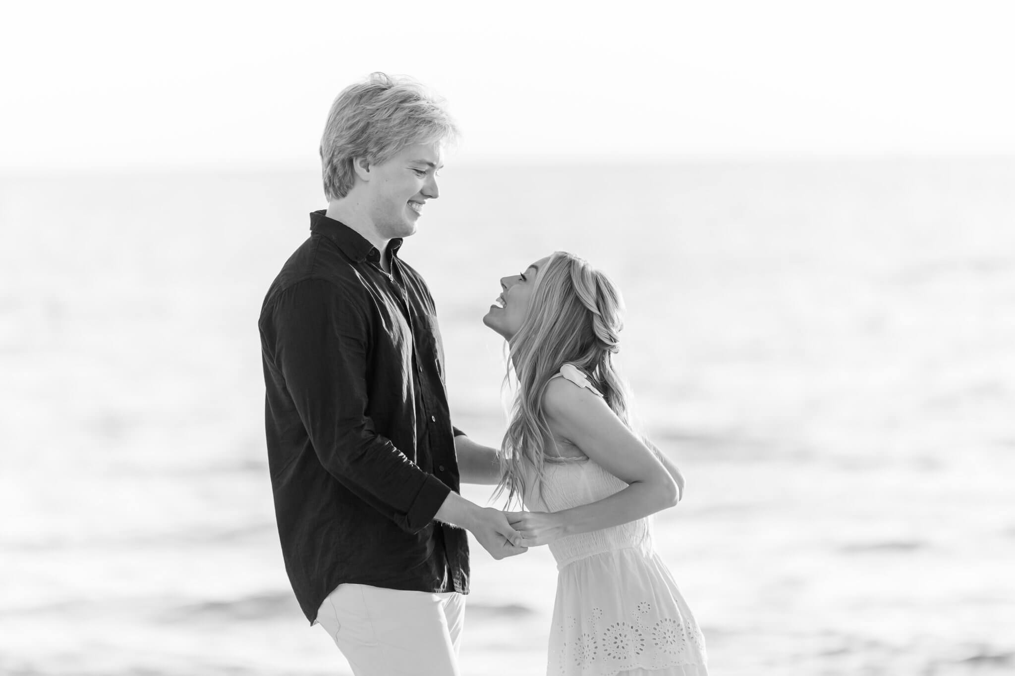 man and woman happily embracing on beach taken by naples photographer