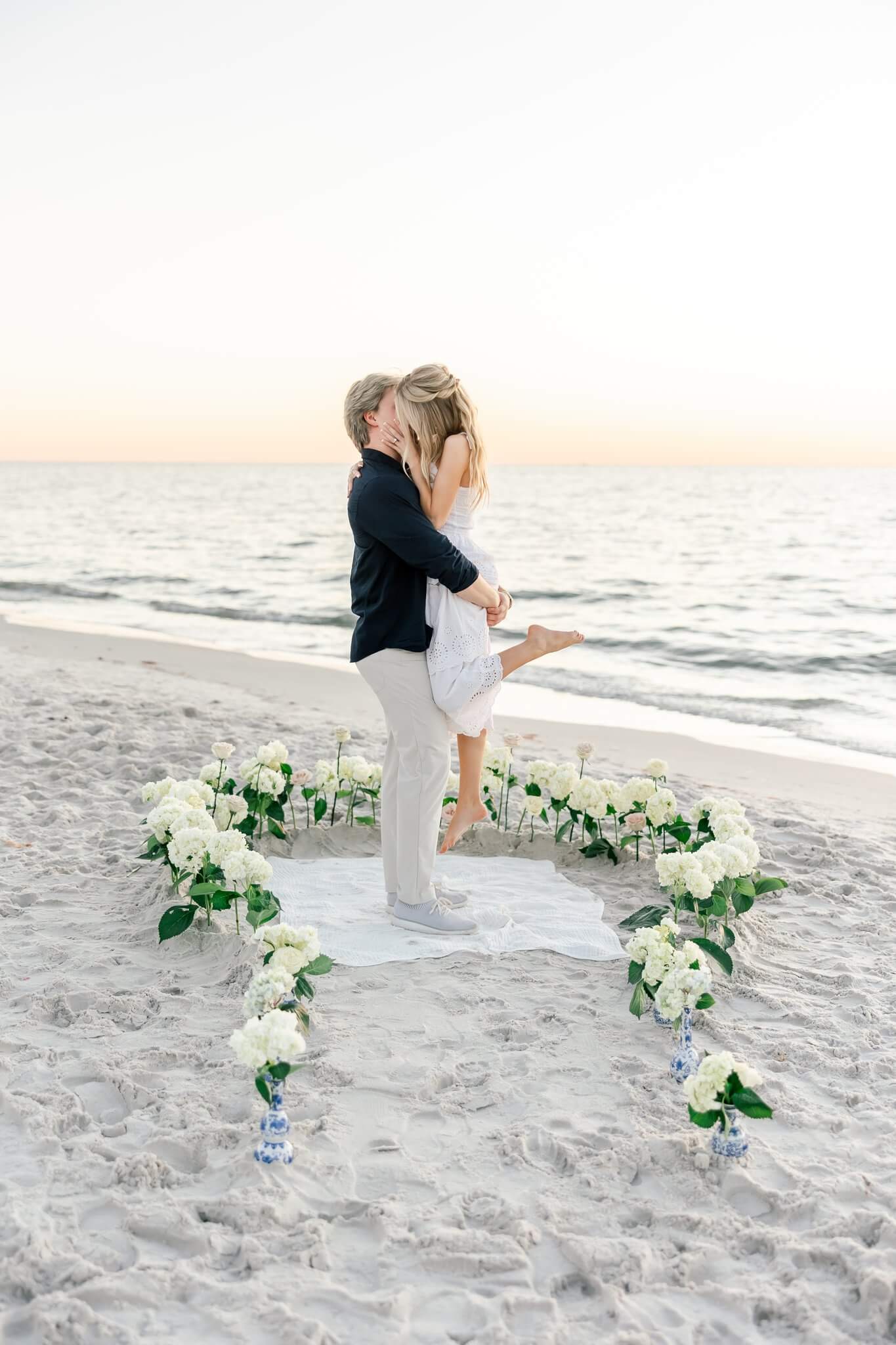 couple kissing surrounded by flowers near the ocean by photographers naples fl