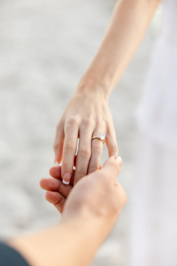 photo of engagement ring and holding hands by photographers naples fl