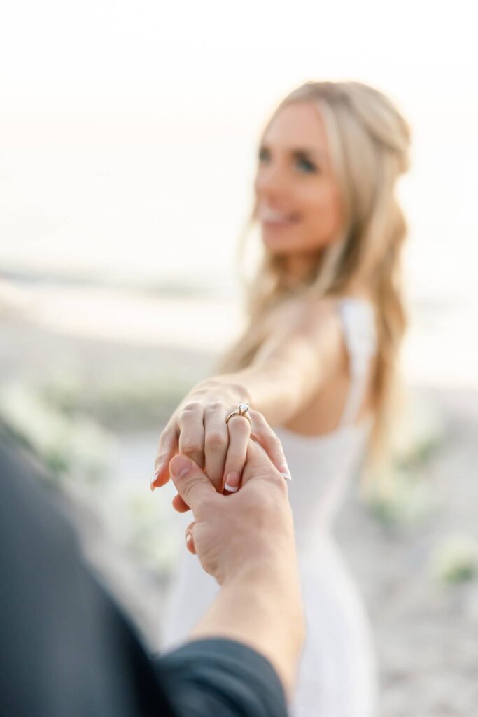 photo of engagement ring and holding hands by photographers naples fl