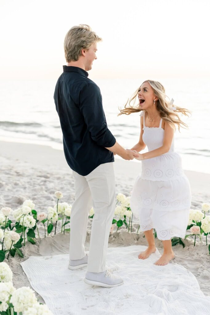 woman excitedly jumping after getting engaged on beach by photographers naples fl