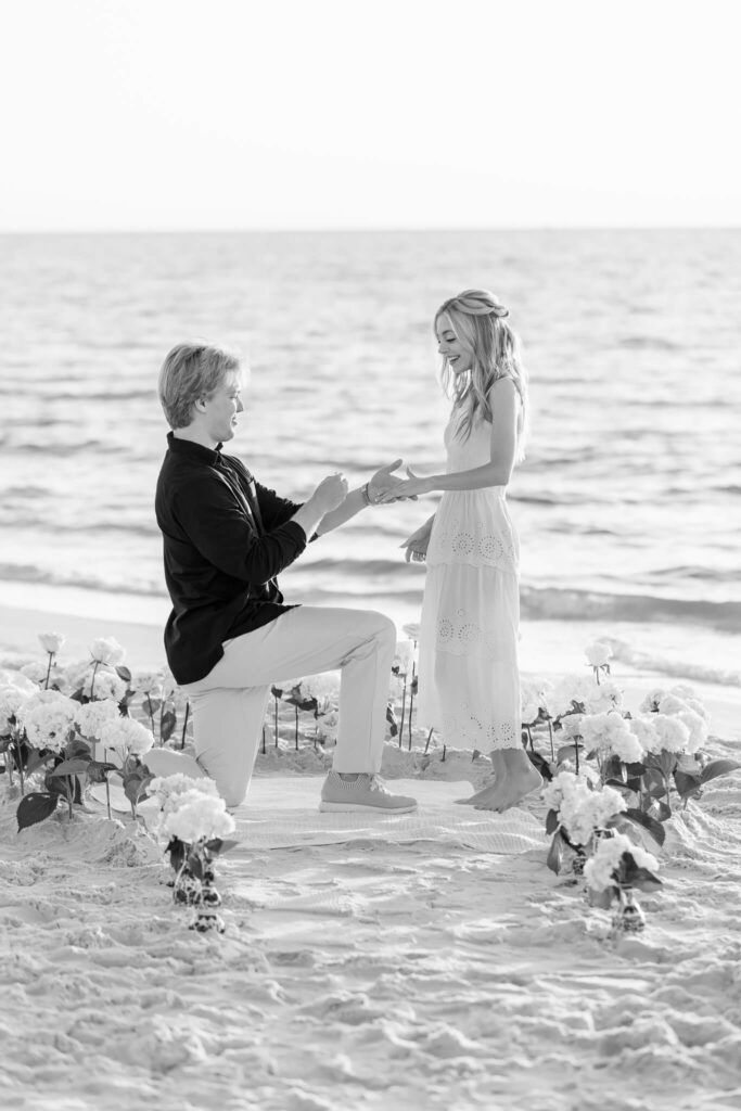 man on his knee proposing to woman taken by one of the naples photographers