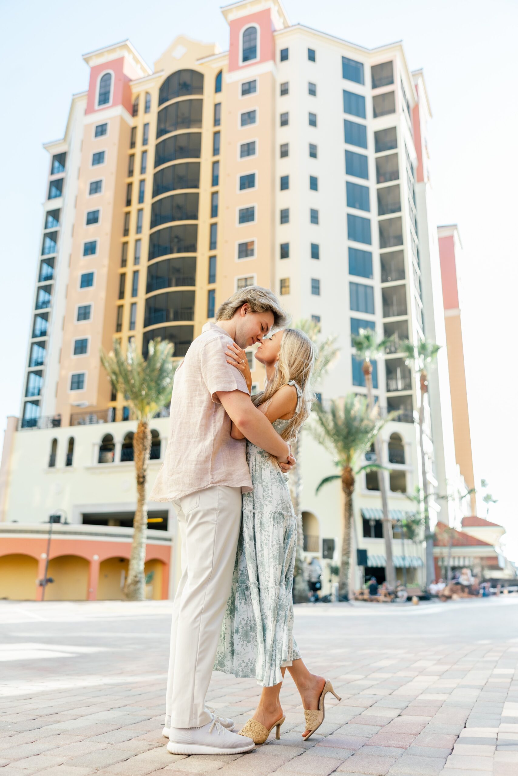 couple kissing and embracing in front of building at cape harbour marina cape coral fl