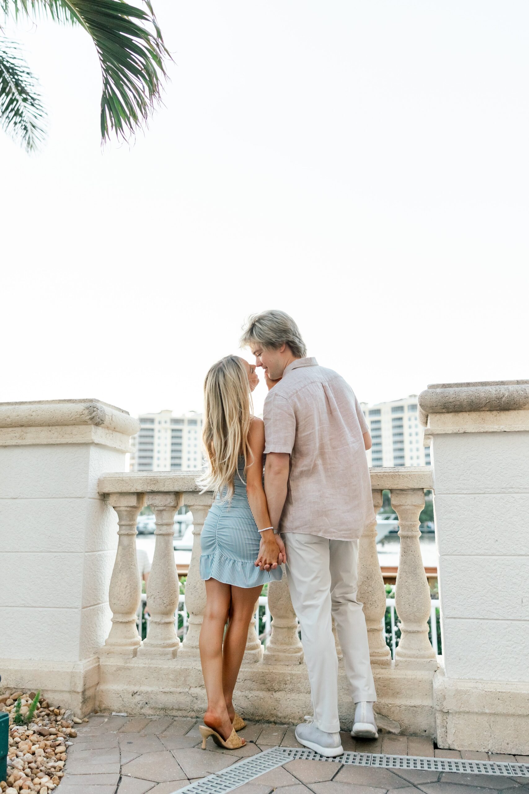 couple holding hands and kissing at cape harbour marina cape coral fl