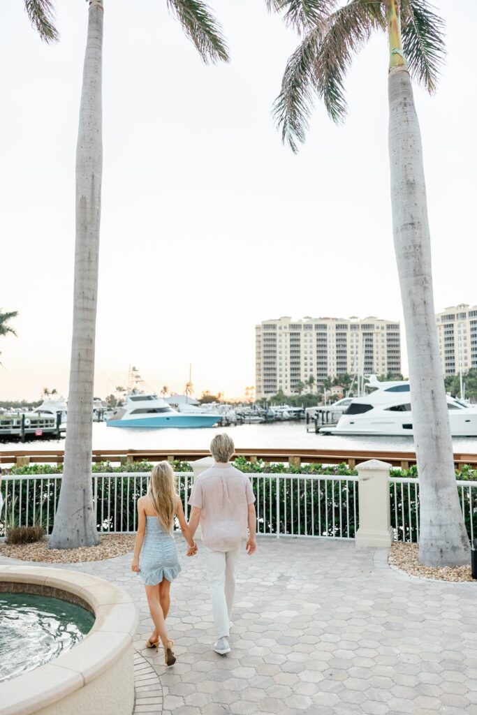 couple walking in front of palm trees at cape harbour marina cape coral fl